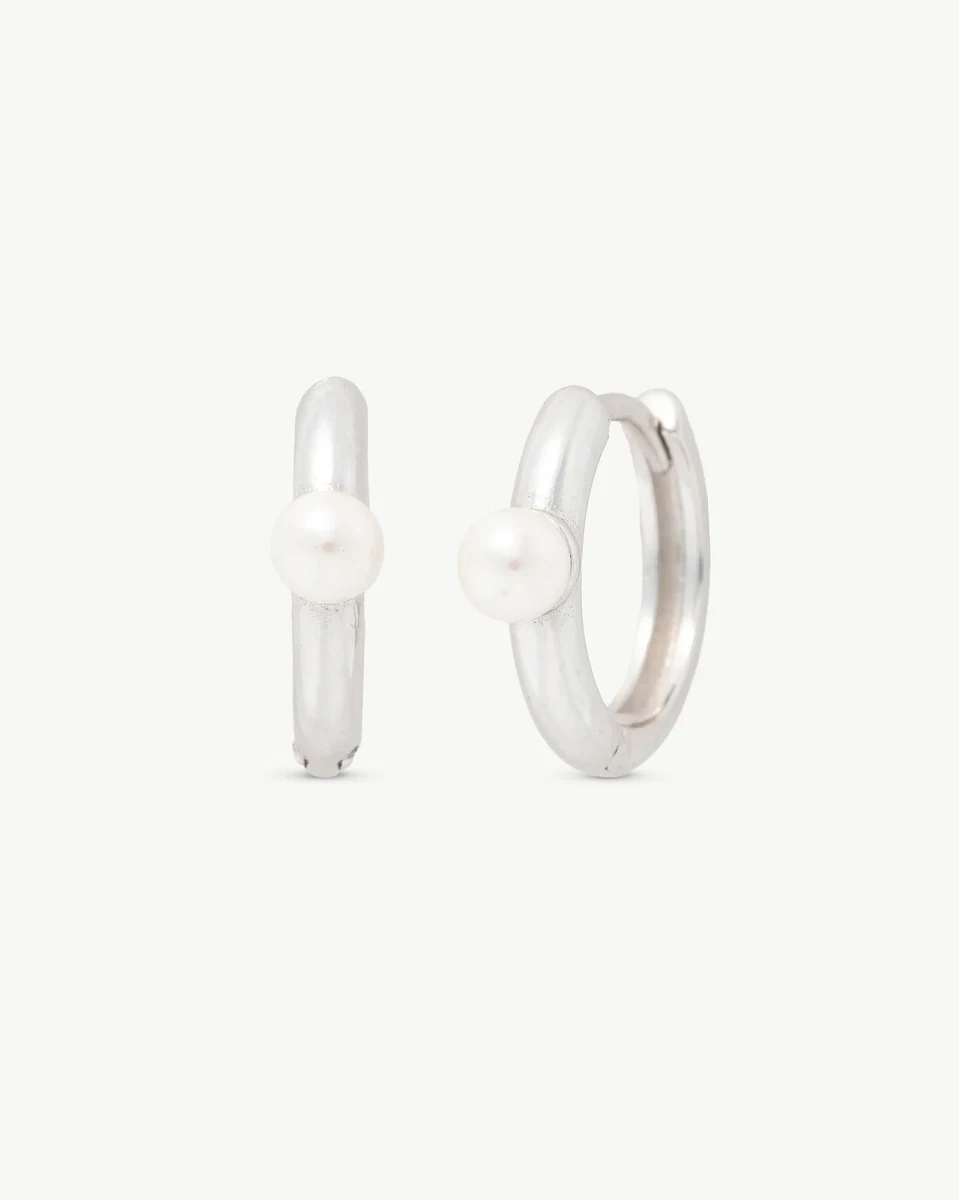 Par de pendientes de aro con perla, vista frontal ligeramente angulada sobre fondo blanco.