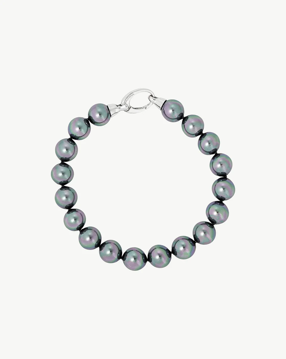 Pearl bracelet arranged in a circle on a white background, top view showing the silver clasp detail.
