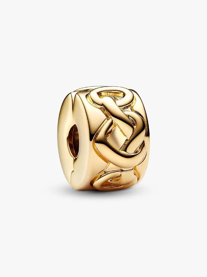 Vista frontal de perfil del charm dorado con motivo de nudo, sobre fondo blanco puro.