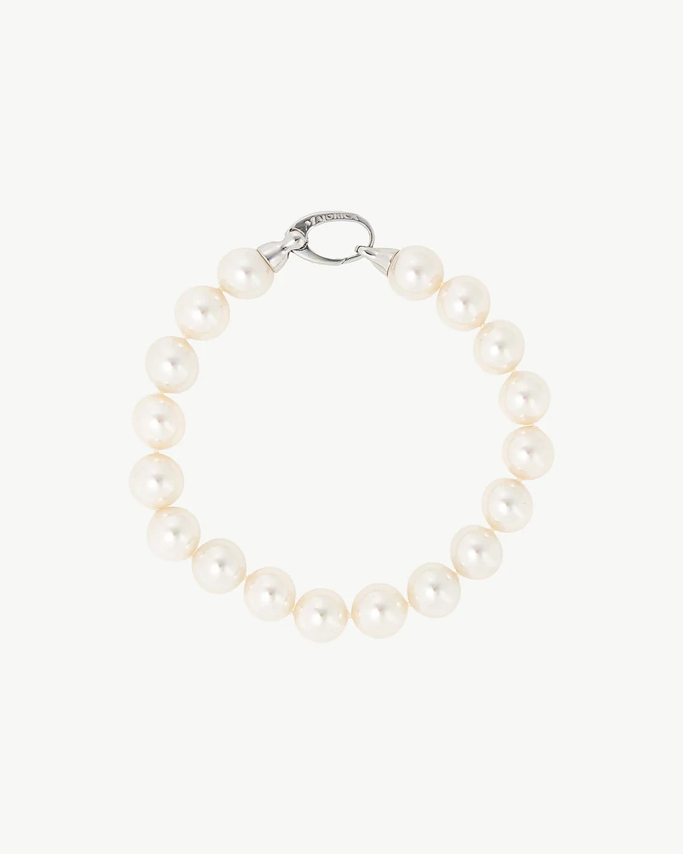 Top view of pearl bracelet in a circular arrangement, neutral white background.