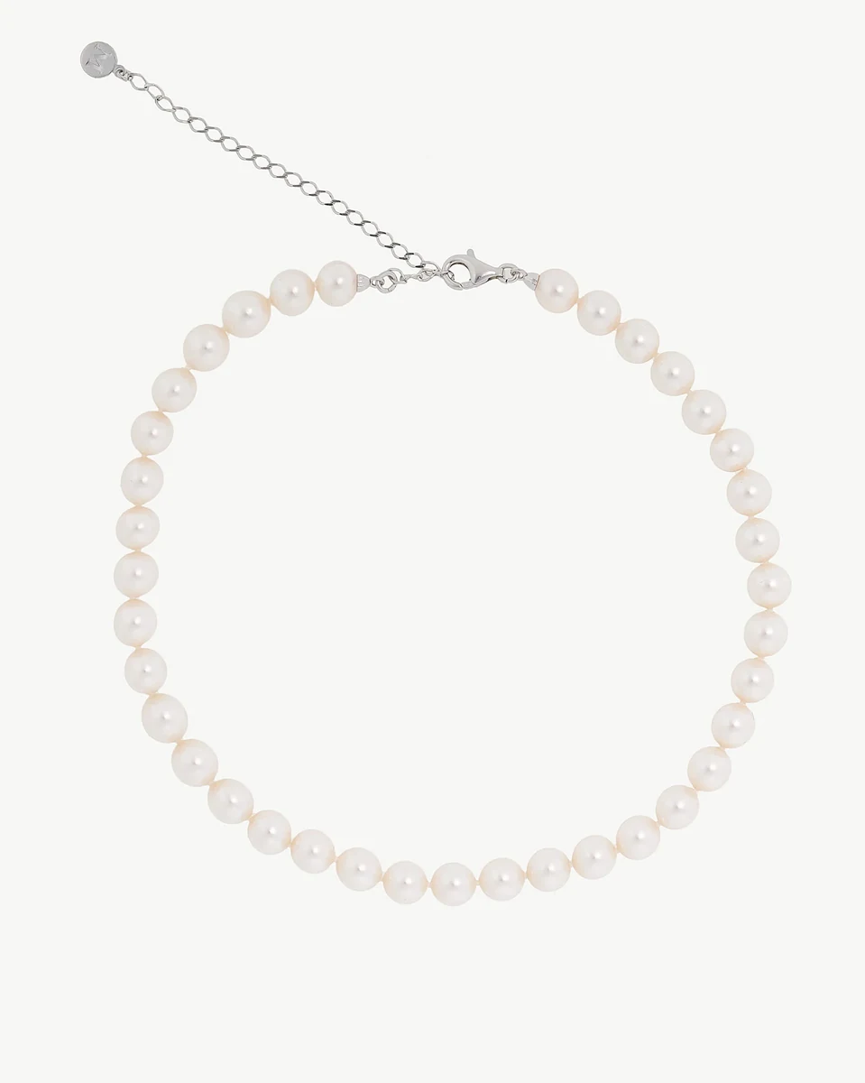 White pearl necklace arranged in a circle on a white background, front view showing clasp and extender chain.