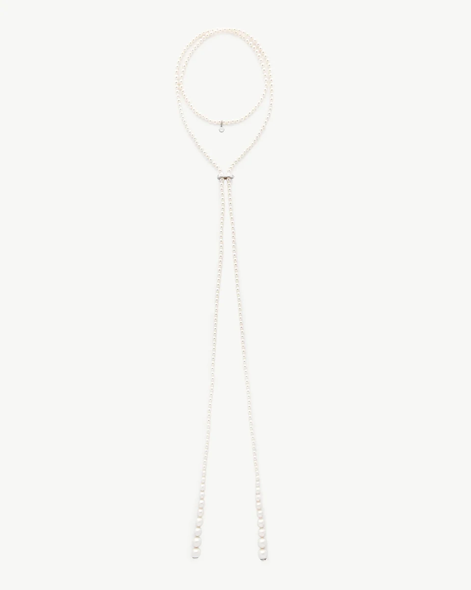 Collier de perles disposé en forme de boucle sur fond blanc, vue frontale complète.