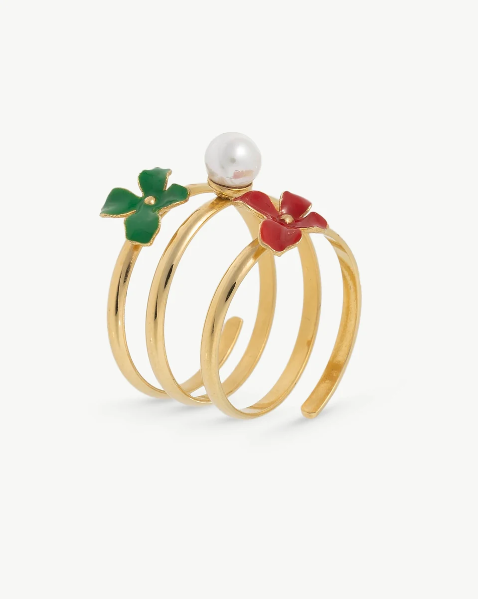 Anillo de diseño espiral con perla y flores esmaltadas, vista lateral en ángulo sobre fondo blanco.