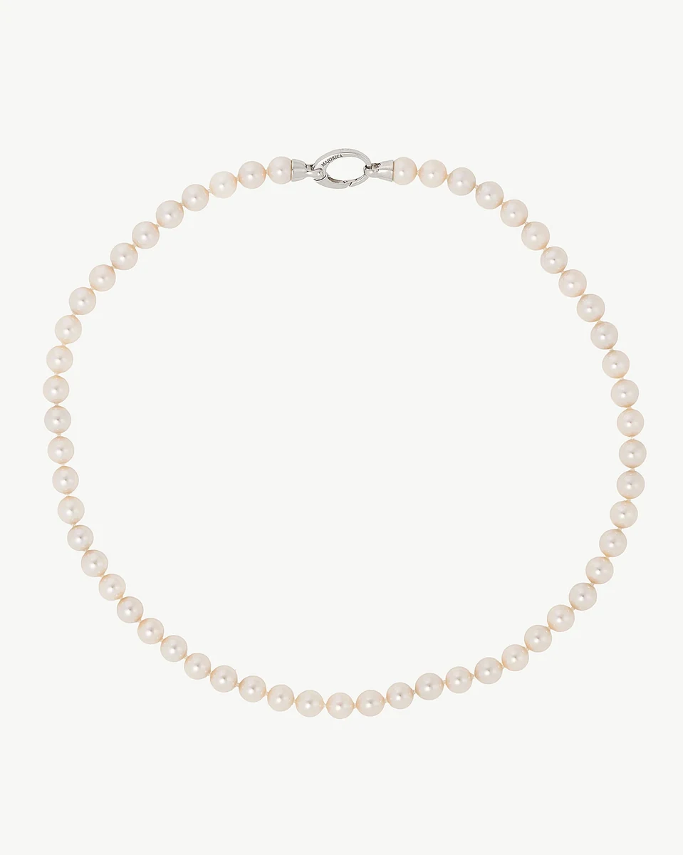 Collier de perles disposé en cercle sur fond blanc, vue frontale complète.