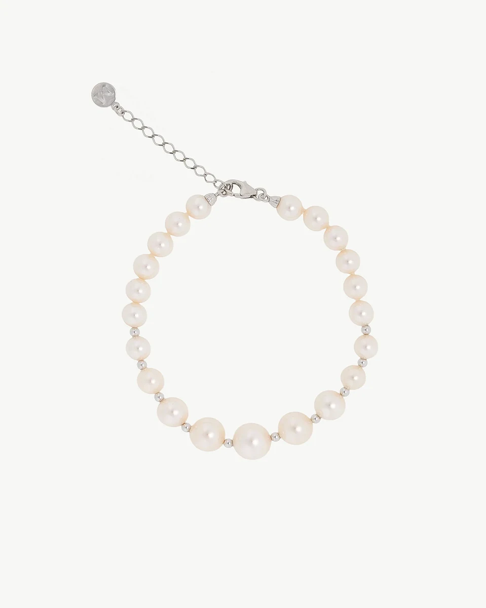 Bracelet en perles disposé en cercle sur fond blanc, vue de dessus avec détail du fermoir et chaîne d'extension.