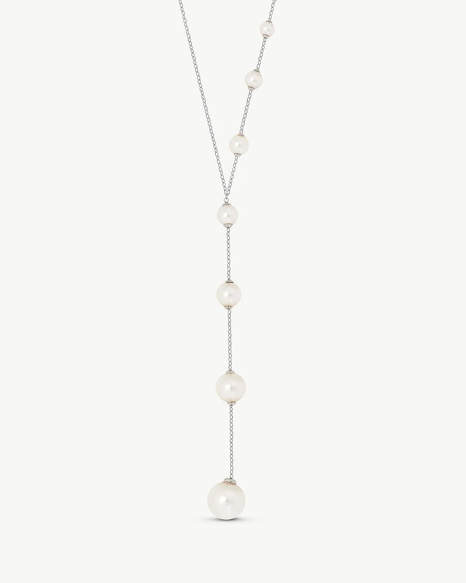 Long necklace with white pearls arranged vertically on a white background, full front view.