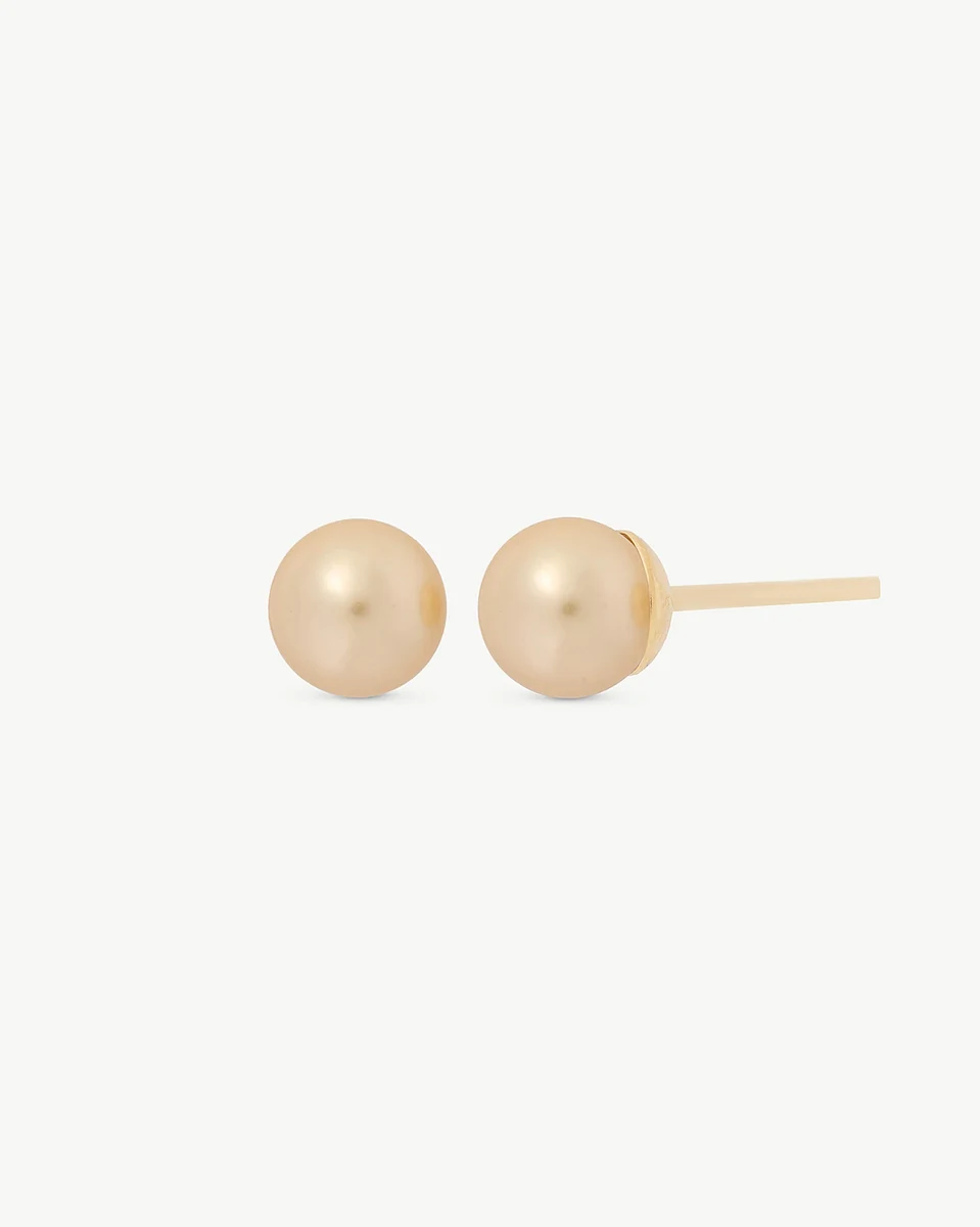 Side view of champagne pearl stud earrings on a white background, showing the gold post.