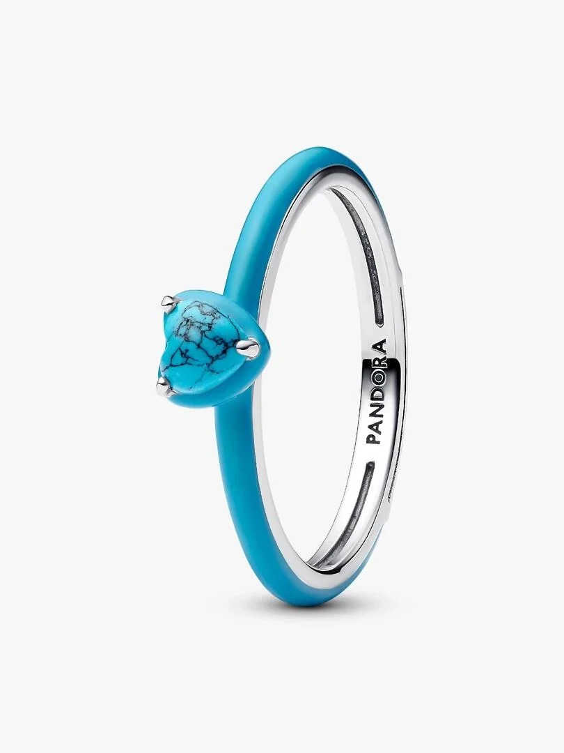 Silver ring with turquoise band and heart-shaped gem, side view on a white background.