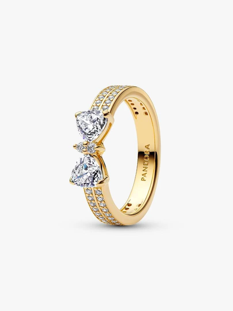 Anillo de doble banda con motivo de lazo y circonitas, vista lateral en ángulo sobre fondo blanco.