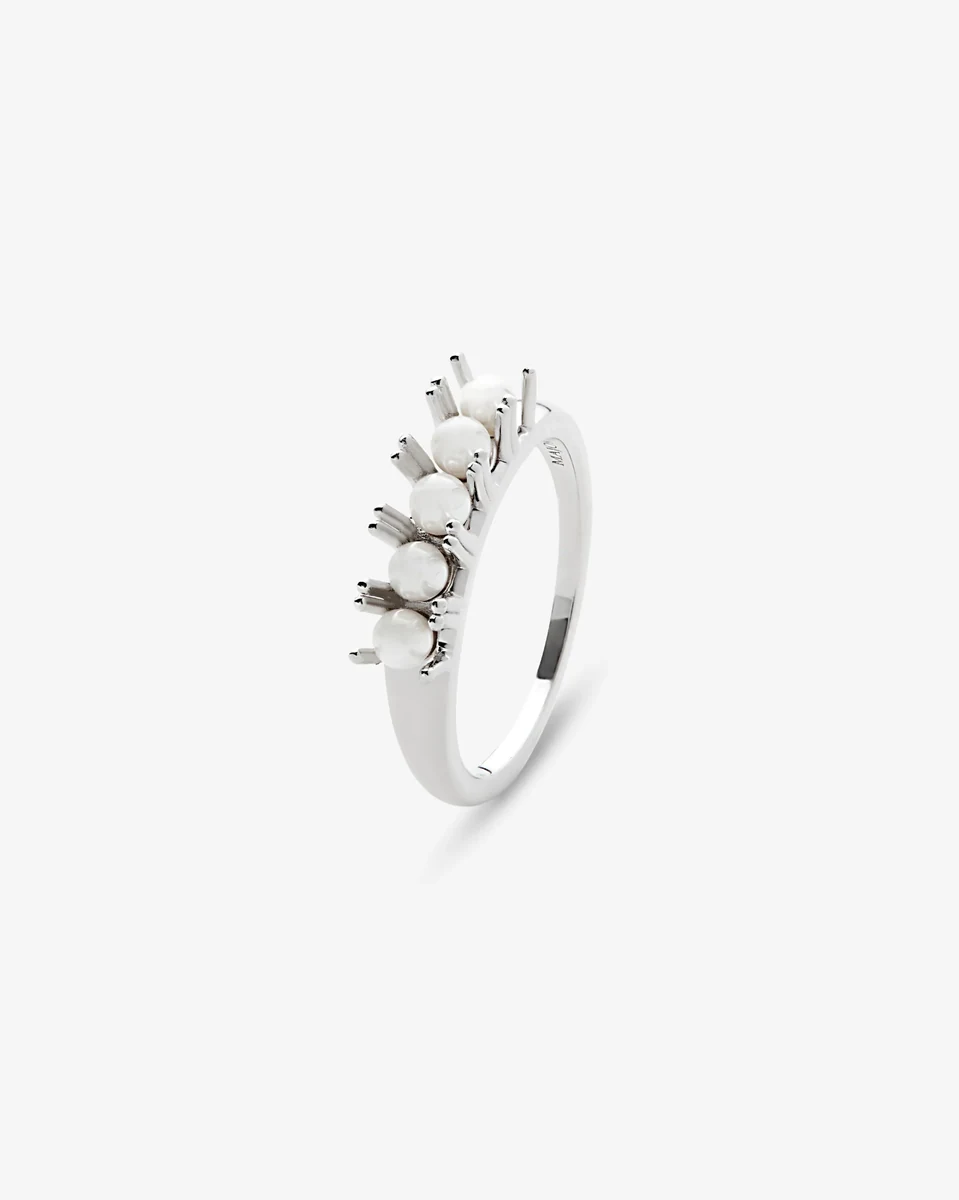Bague aux perles vue de profil sur fond blanc, gros plan sur les sertissages et les perles blanches.