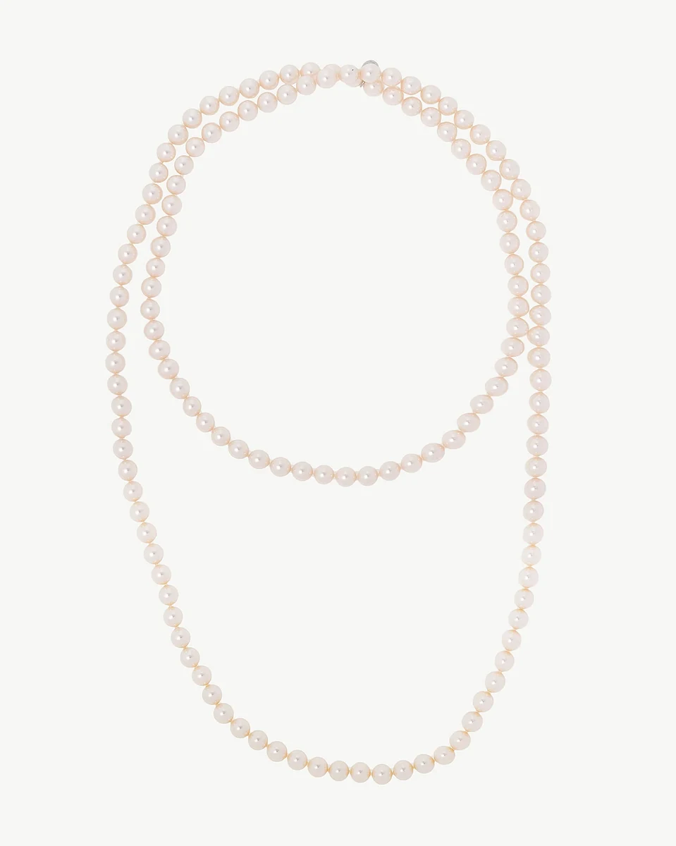Pearl necklace arranged in two loops on a white background, top-down front view.