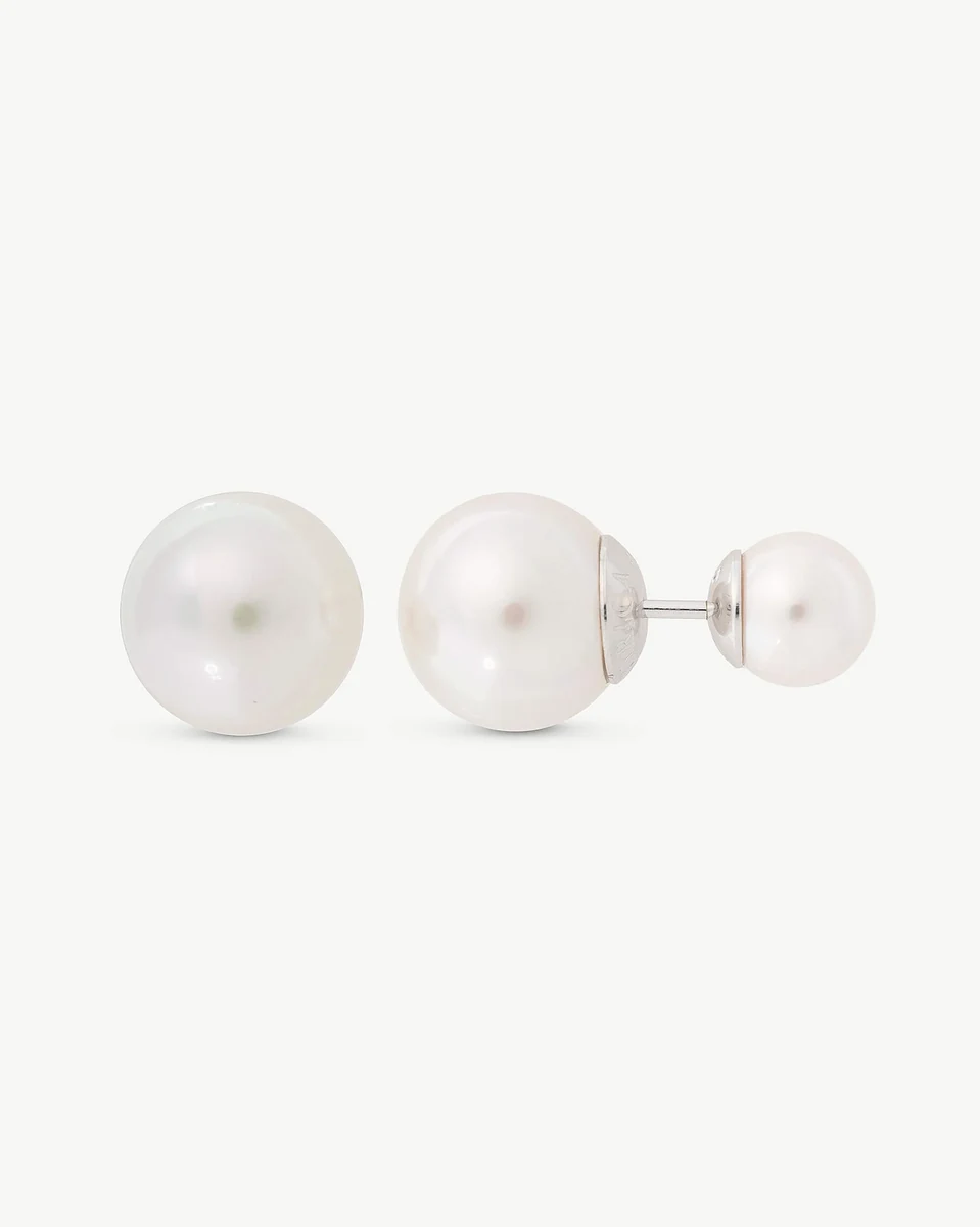 Dubbele parel oorbellen in profiel op een witte achtergrond, met focus op de twee bollen en zilveren stift.
