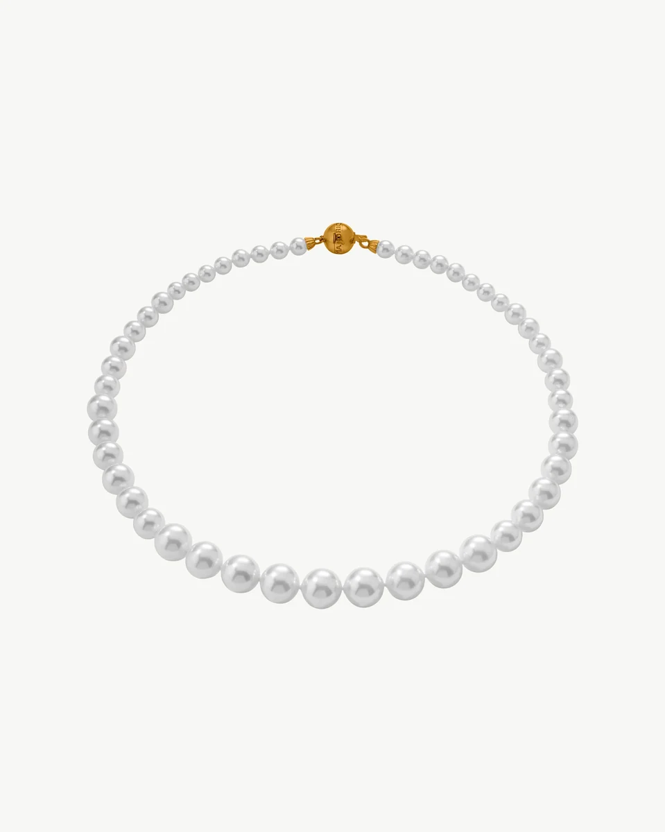 Pearl necklace arranged in a circular shape on a white background, front view with gold clasp visible.