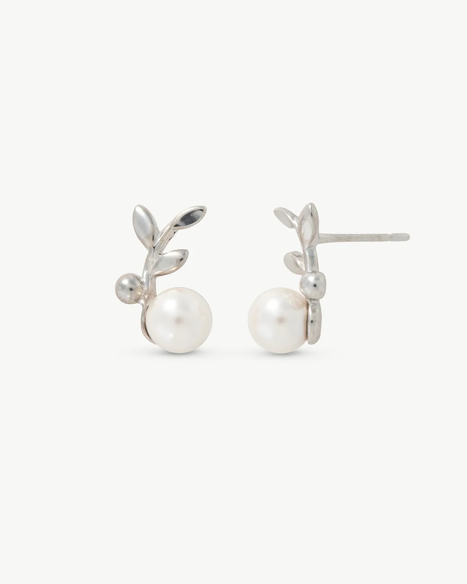 Vooraanzicht van de oorbellen met bladmotief en parel, op een witte achtergrond.