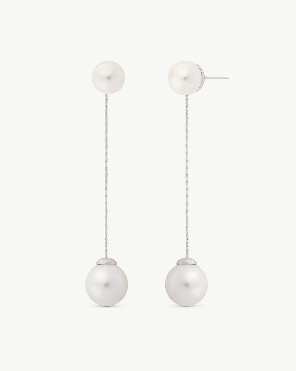 Vooraanzicht van de lange oorknopjes op een witte achtergrond, met focus op de verticale lijn en parels.