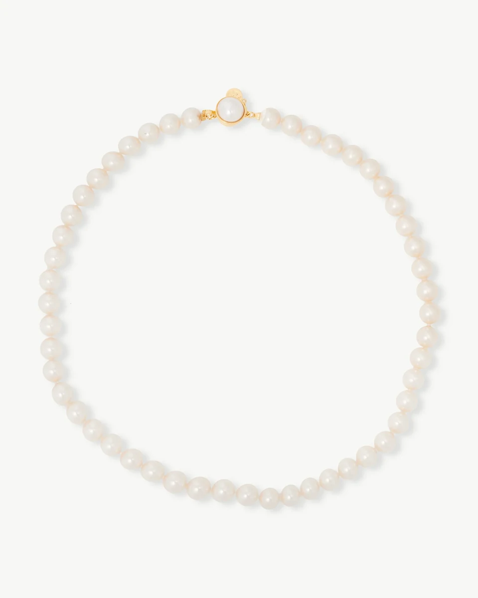 White pearl necklace arranged in a circle on a white background, front view with gold clasp visible.