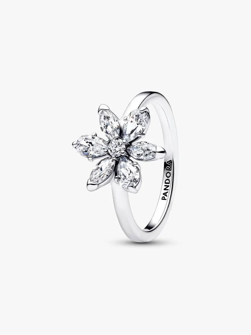 Bague fleur vue de profil, fond blanc, gros plan sur le relief floral et les pierres transparentes.