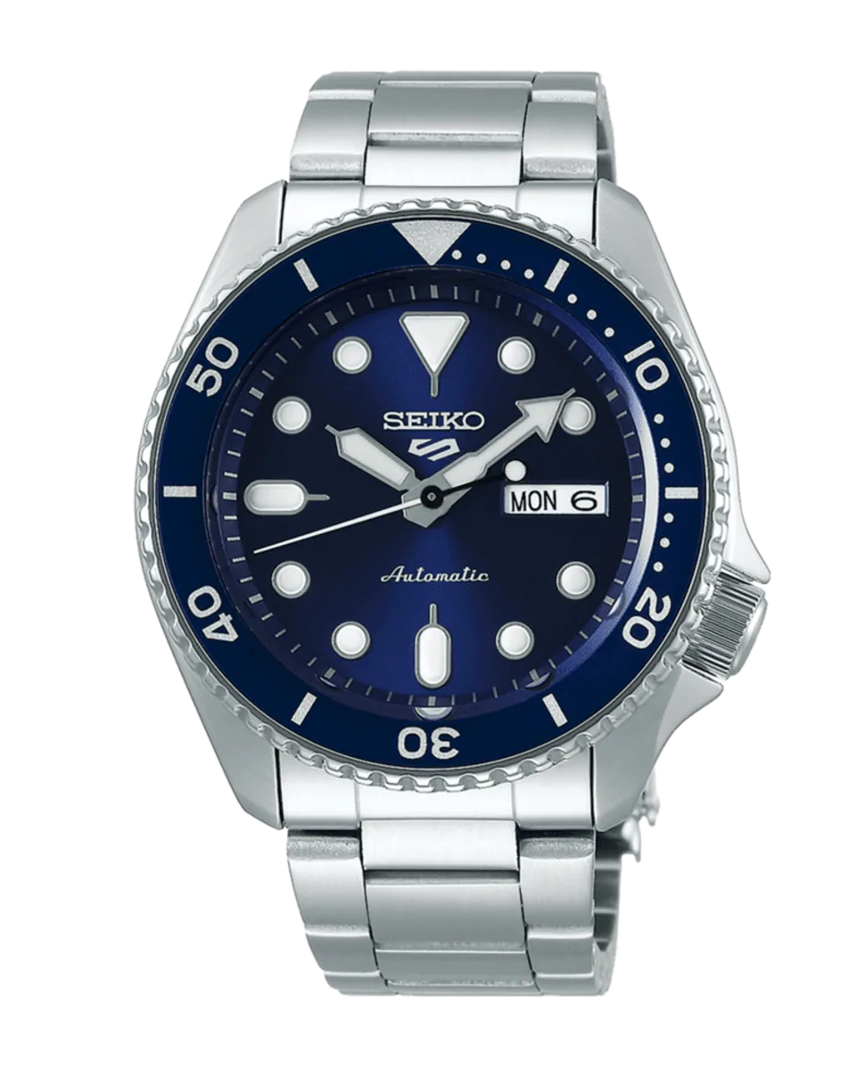 Vista frontal del reloj con esfera azul y brazalete de acero sobre fondo blanco.
