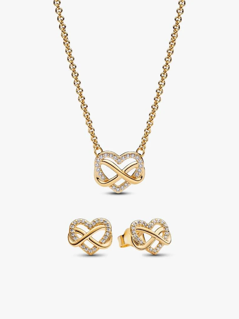 Collar y pendientes de corazón con filigrana sobre fondo blanco, vista frontal centrada.