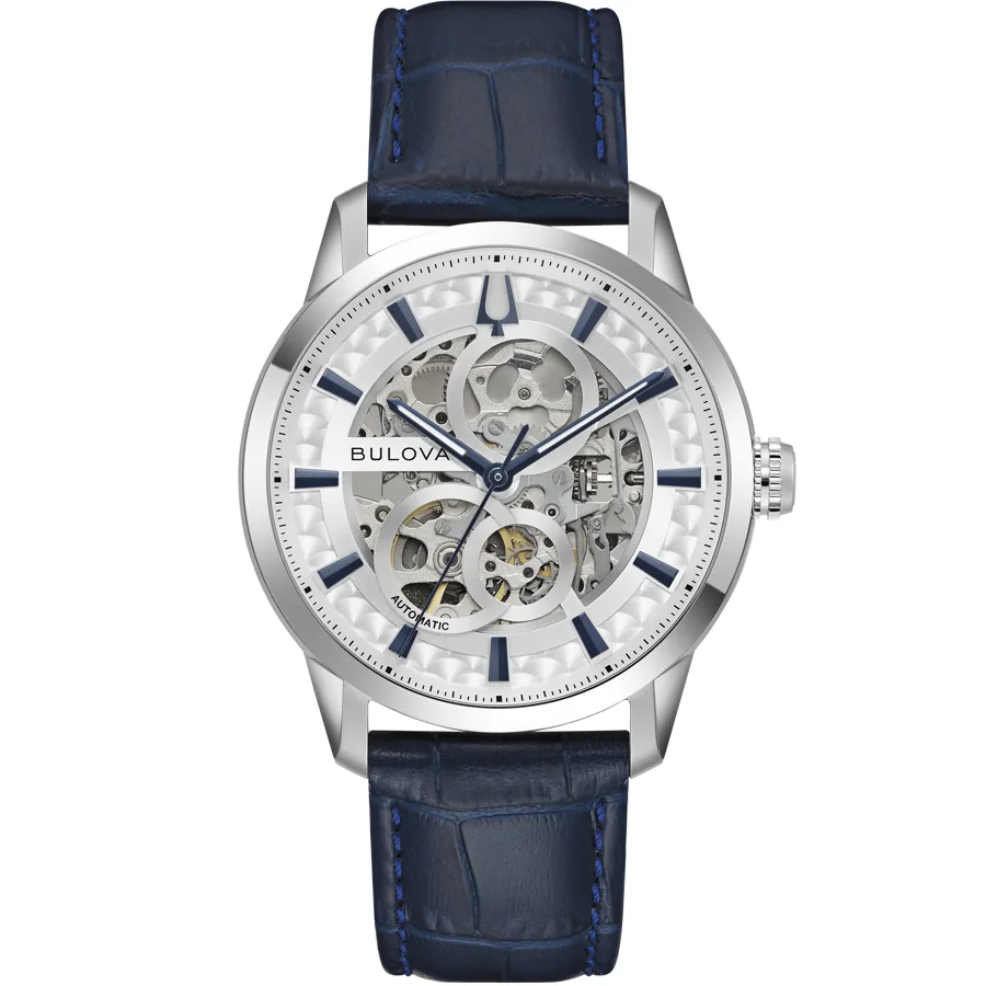 Reloj de pulsera visto de frente sobre fondo blanco, esfera skeleton y correa de piel azul.