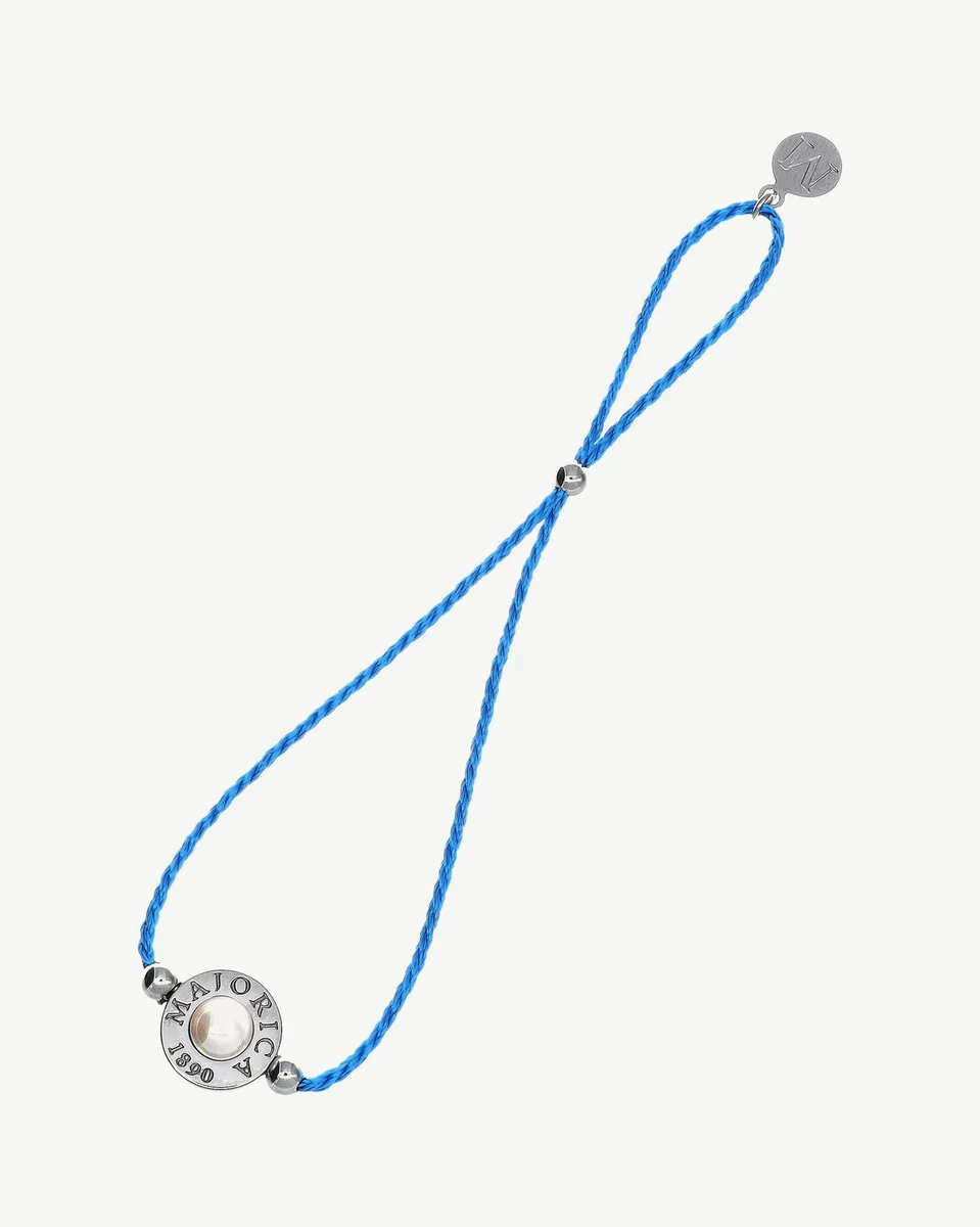 Blue braided cord bracelet with central pearl and metal charm, front view on white background.