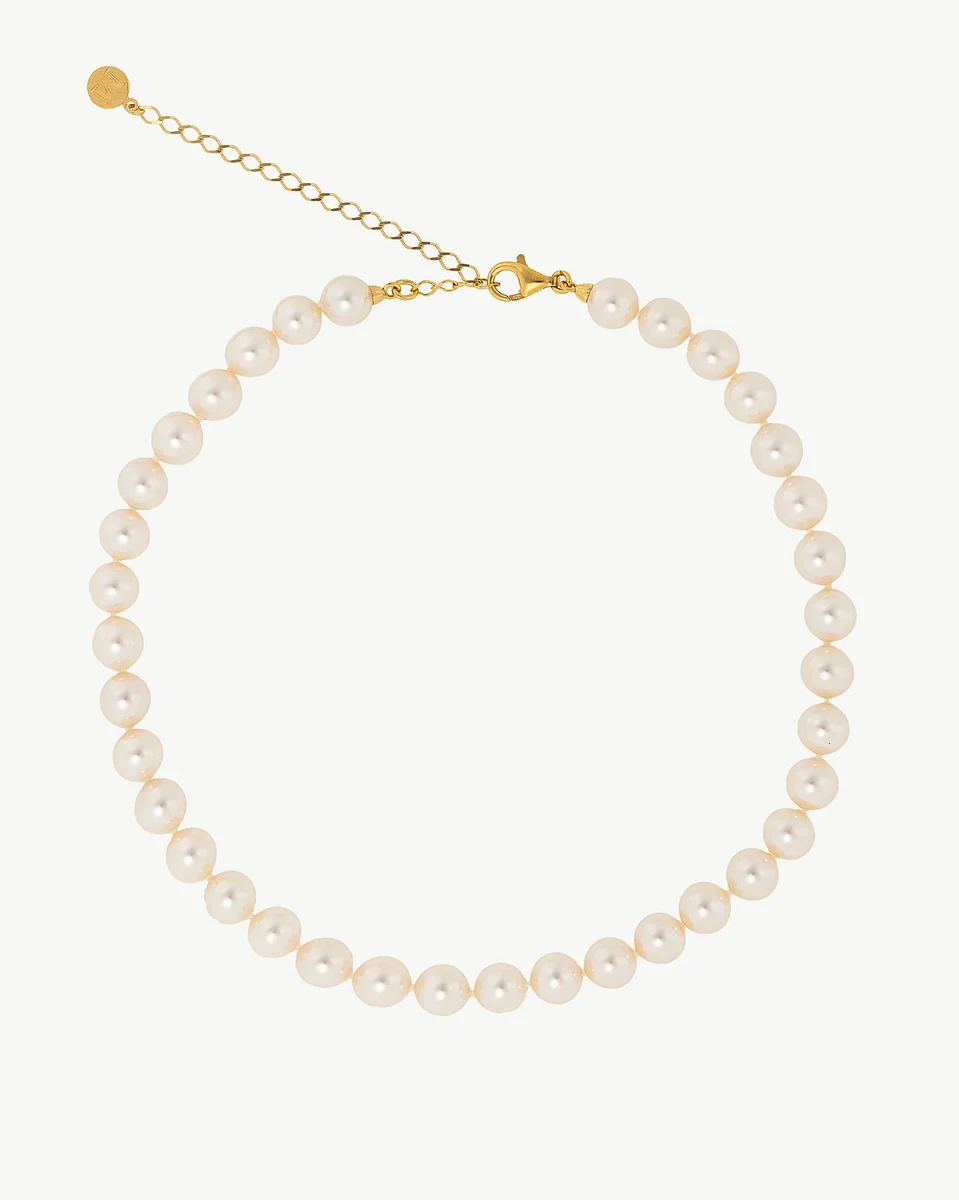 Pearl necklace arranged in a circle on a white background, front view showing clasp and extender chain.