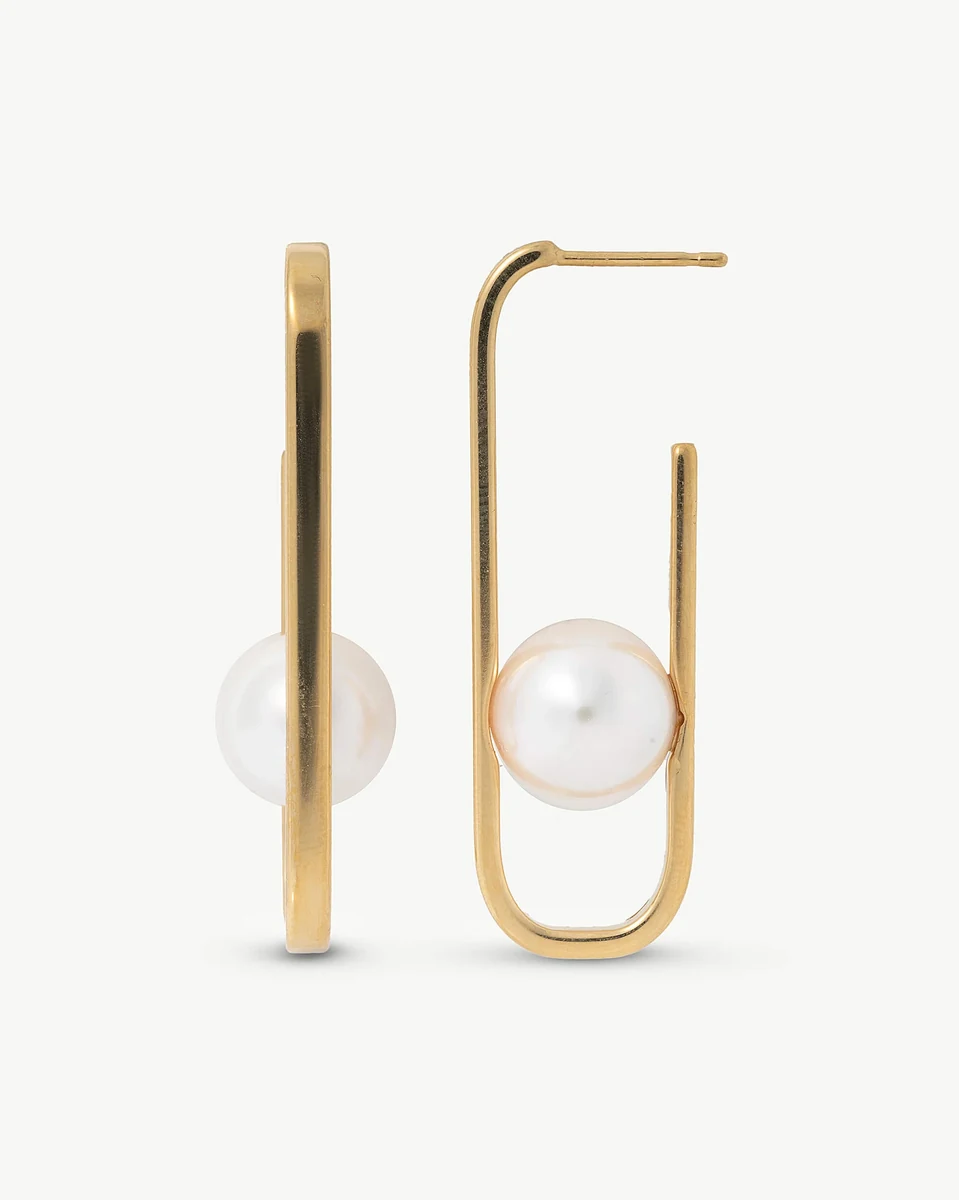 Vooraanzicht van de oorbellen met witte parels en gouden ovale structuren op een witte achtergrond.