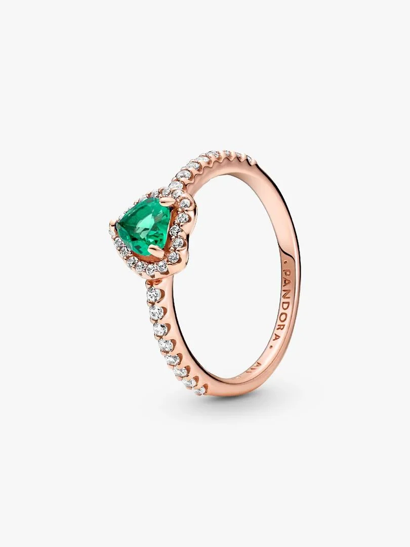 Rose gold ring with green heart-shaped center stone, side view on a white background.