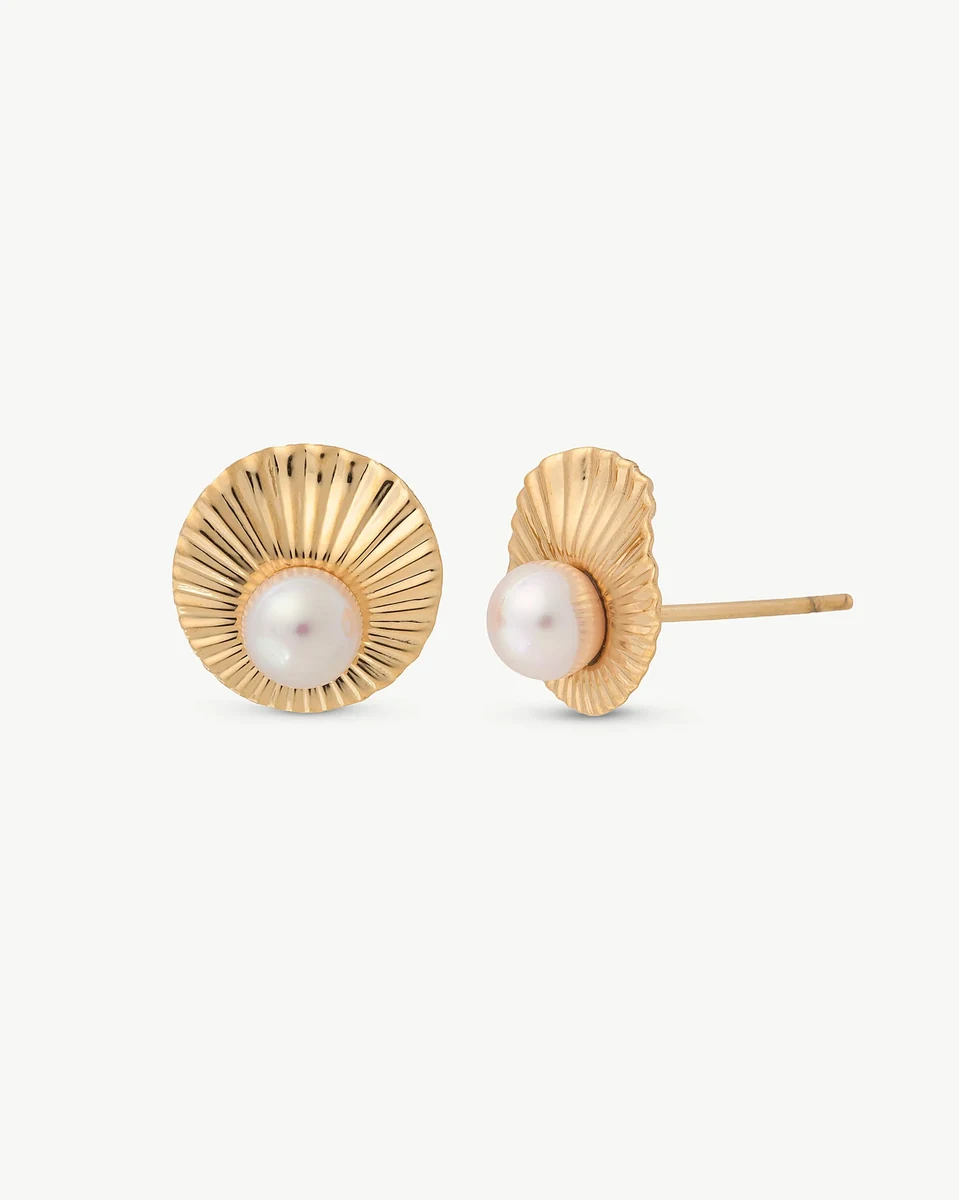 Front view of pearl stud earrings with gold-tone fluted base, isolated on white background.