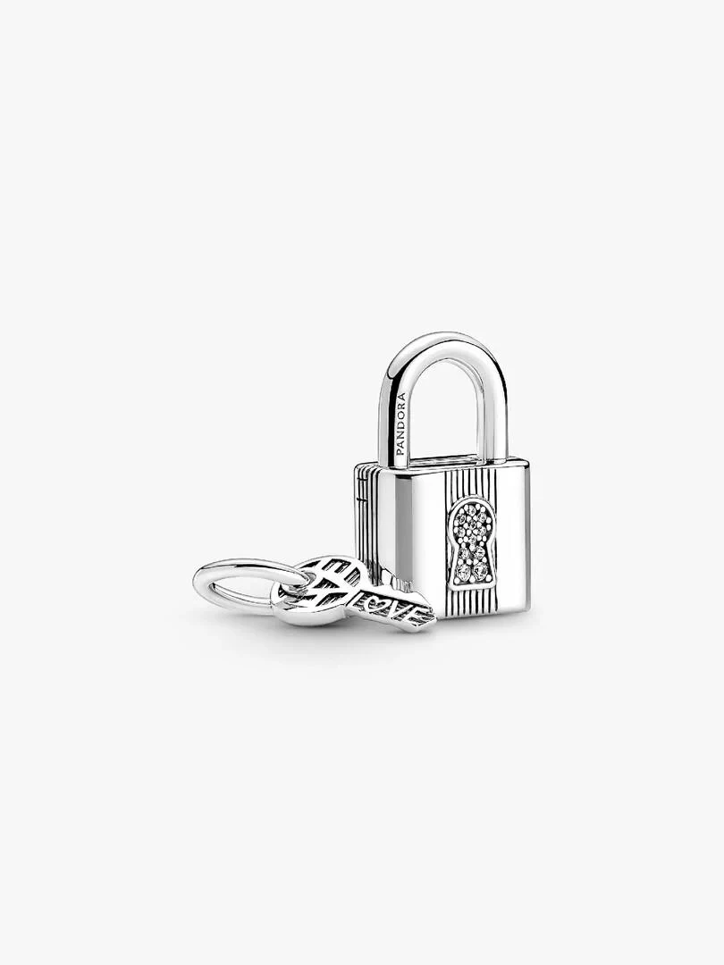 Vue de trois quarts du charm cadenas et clé en argent sur fond blanc.