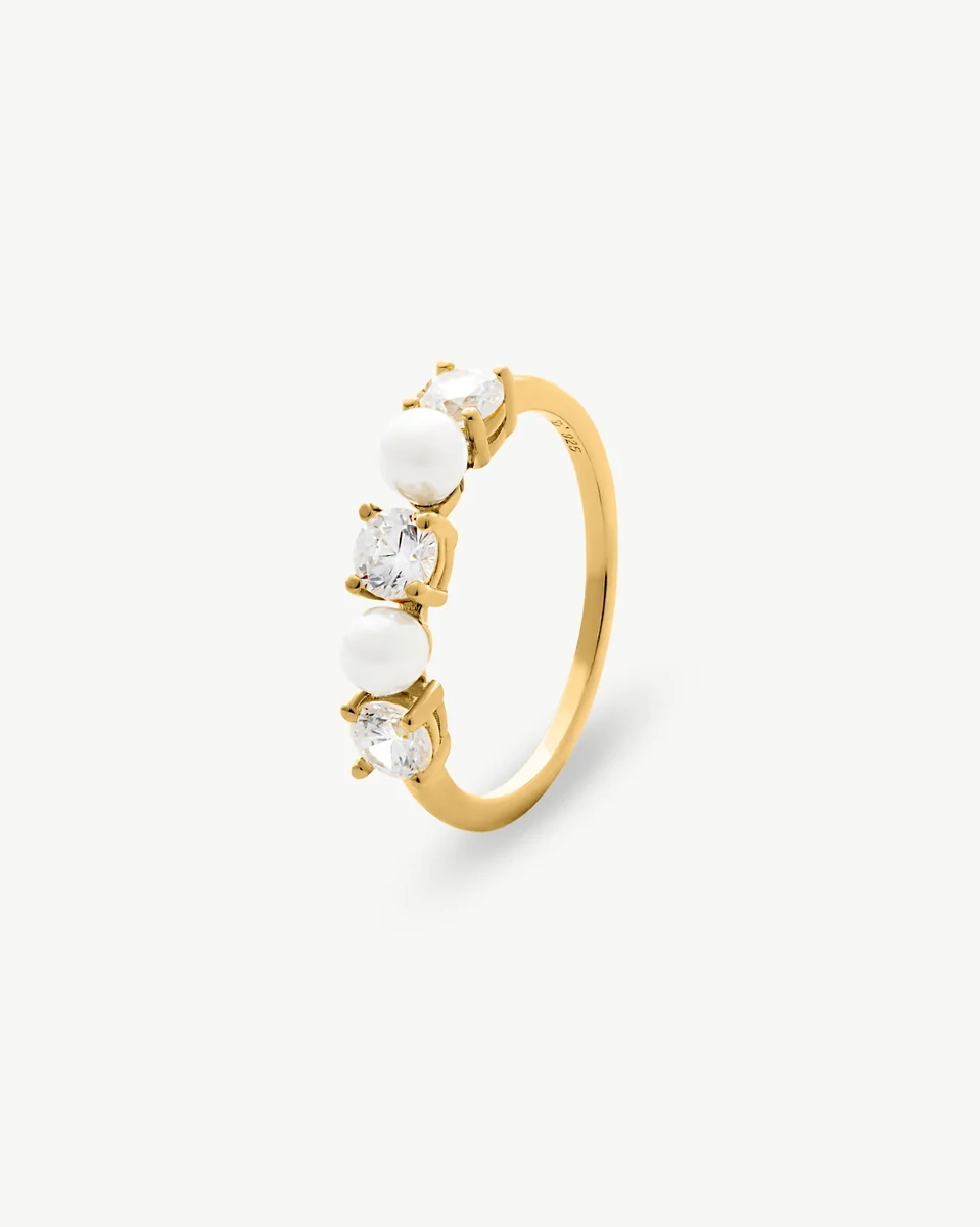 Bague en or avec perles et zircons, vue de profil sur fond blanc.