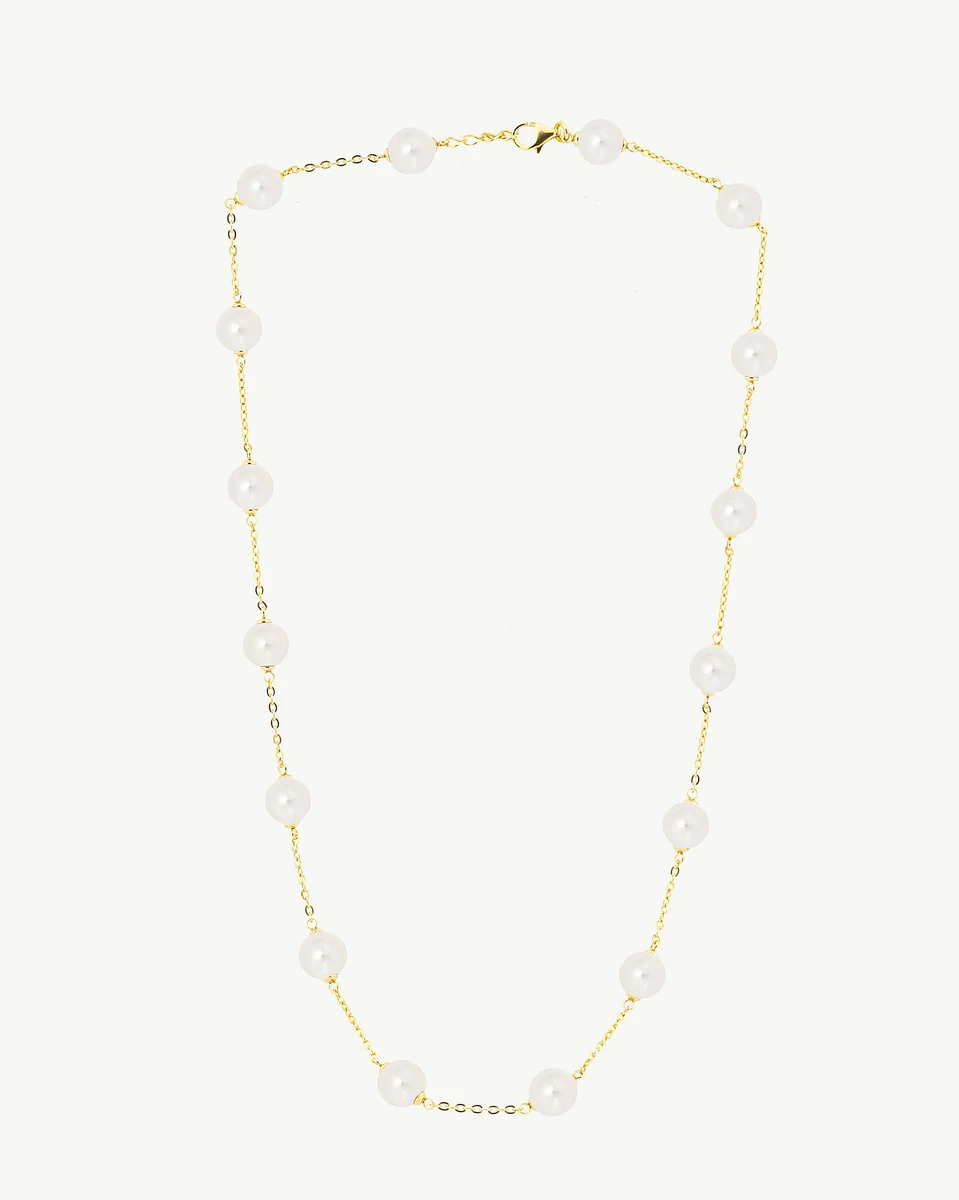 Front view of gold chain and pearl necklace arranged in a U-shape on a white background.