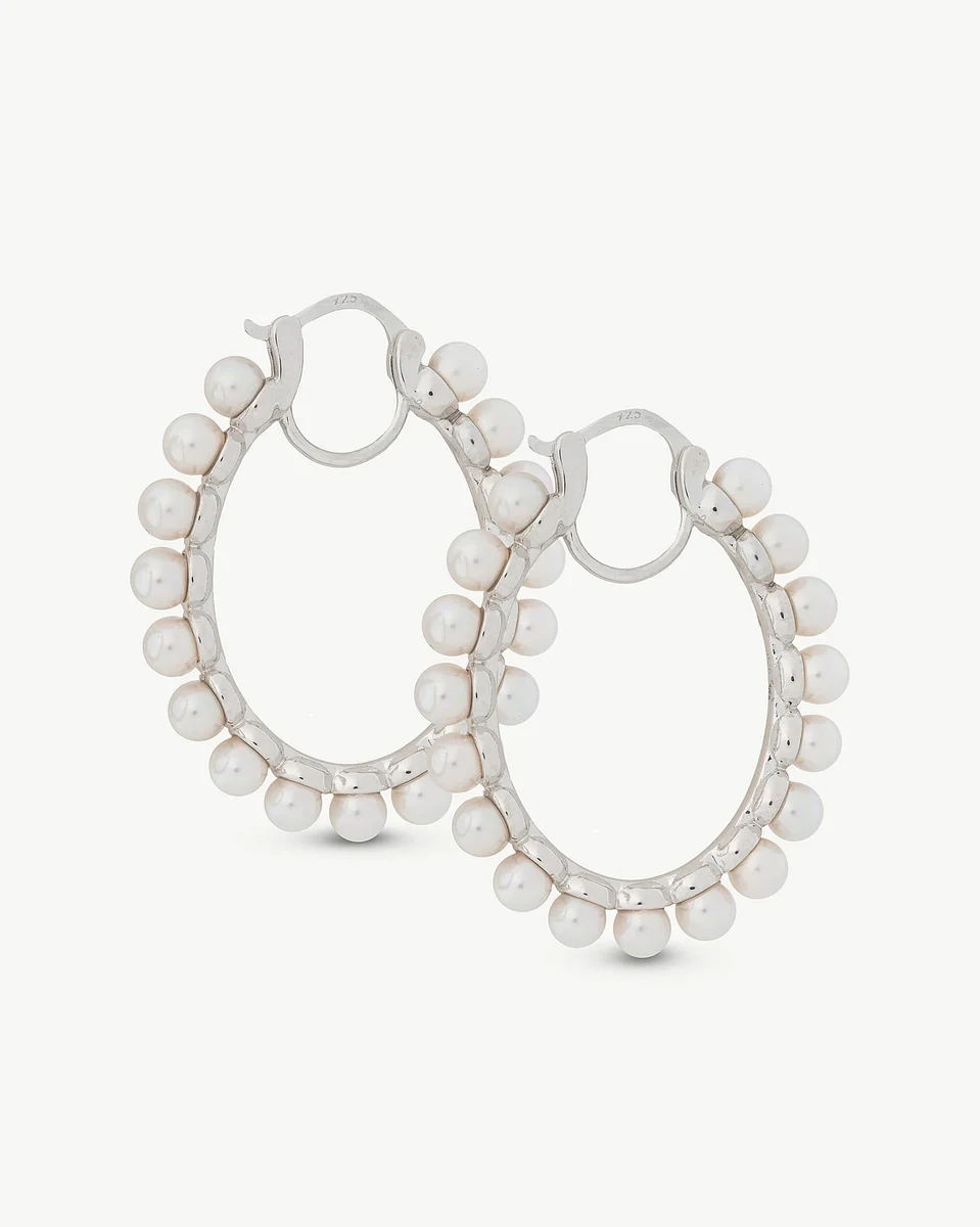 Pair of oval hoop earrings with white pearls, front view on a white background.