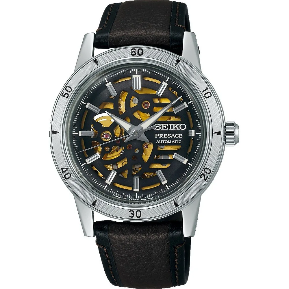 Vista frontal del reloj con esfera esqueleto y correa de cuero marrón sobre fondo blanco