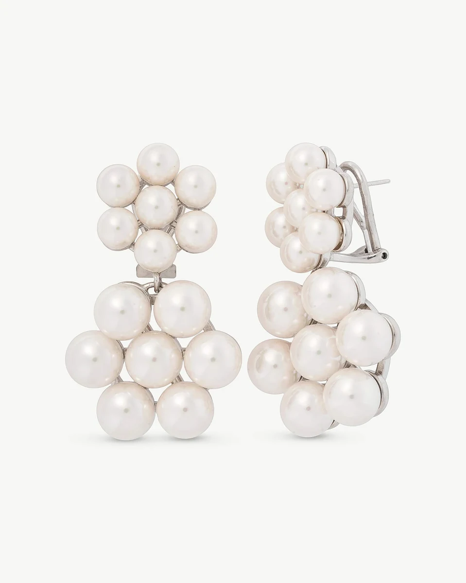 Front view of long white pearl earrings on a white background, showcasing the floral design.