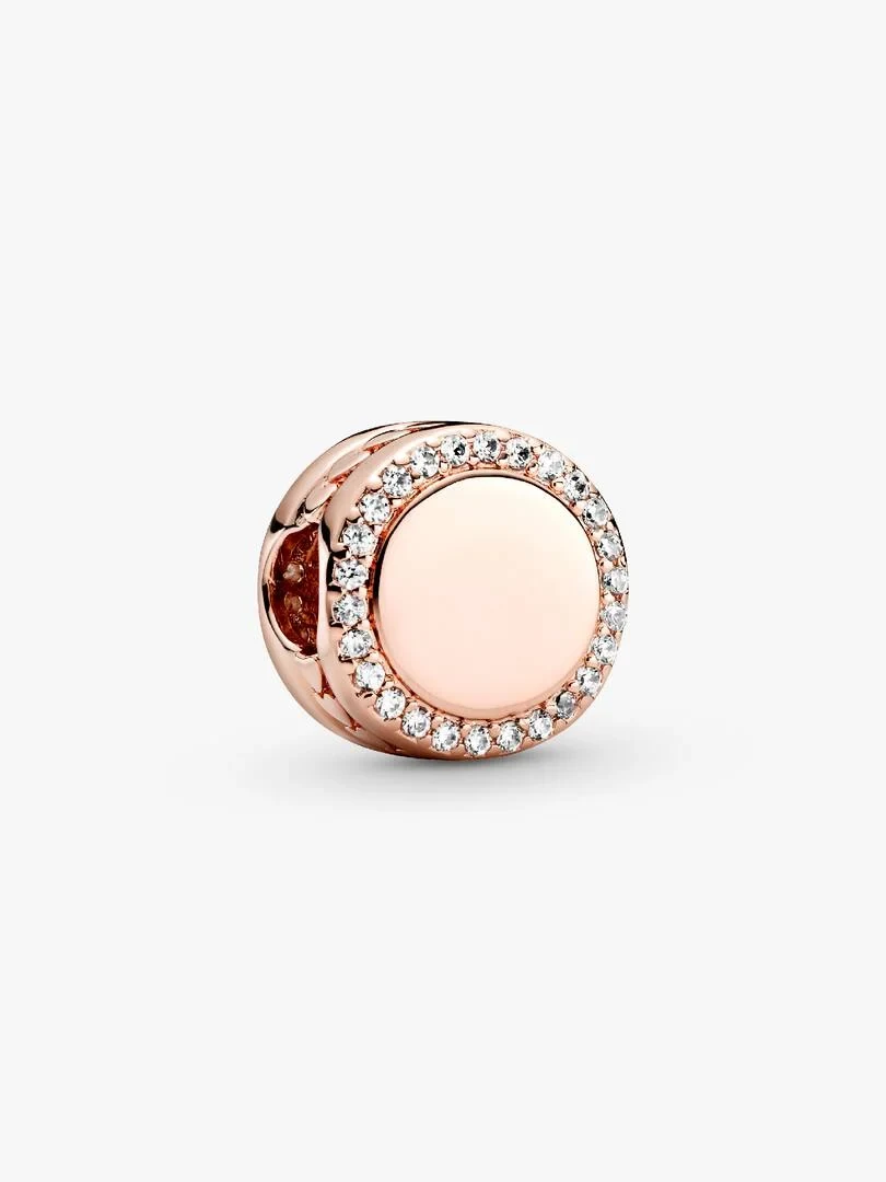 Charm circulaire en or rose avec halo de zircons, vue frontale de trois quarts sur fond blanc.