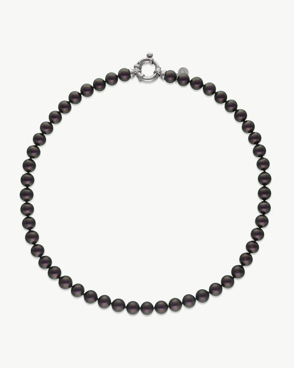 Collier de perles noires disposé en cercle sur fond blanc, vue frontale complète.