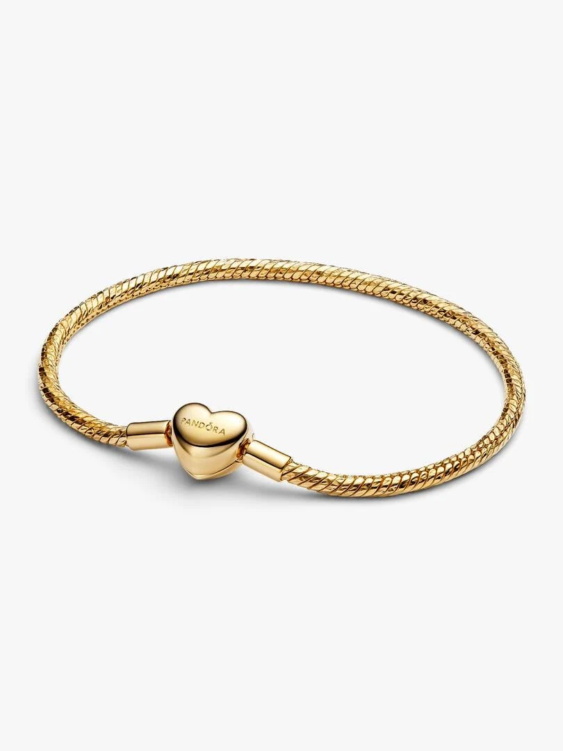 Gold snake chain bracelet in a circular view on a white background, highlighting the faceted heart clasp.