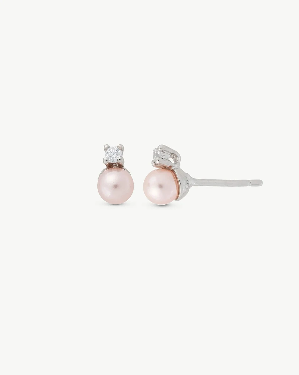Pair of pink pearl and cubic zirconia stud earrings on white background, front and side view.