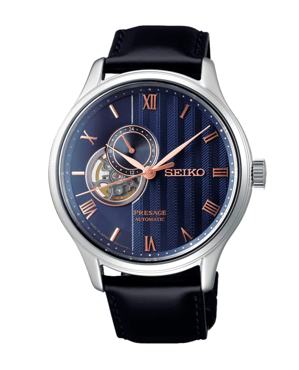 Vista frontal completa del reloj sobre fondo blanco, destacando la esfera azul texturizada y correa de cuero negra.