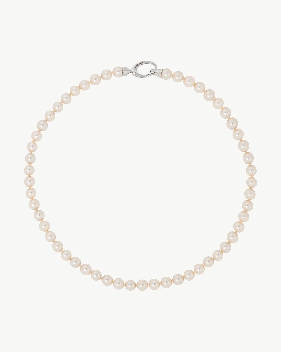 Collier de perles disposé en cercle sur fond blanc, vue de face avec fermoir en argent visible.