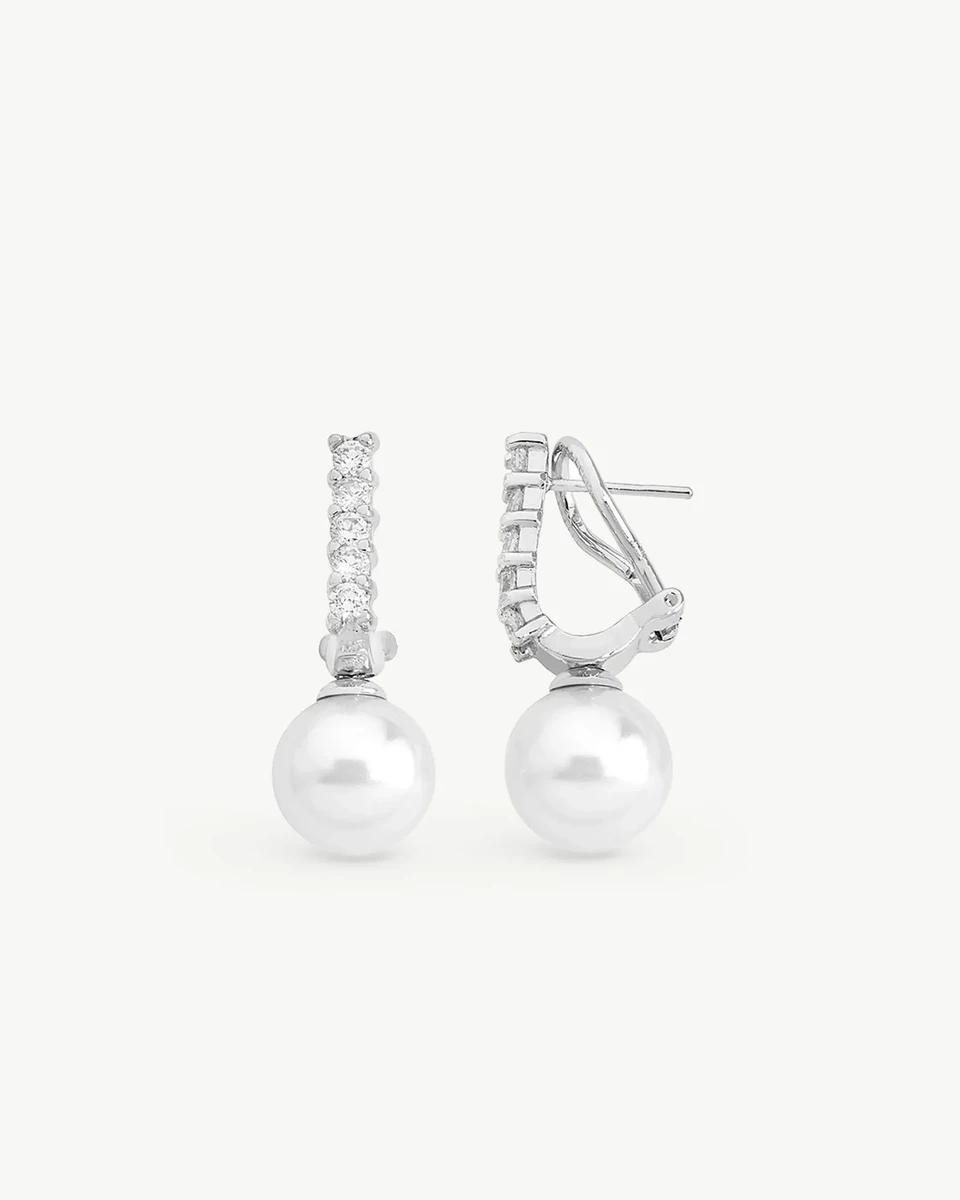 Vista frontal de pareja de pendientes con perlas blancas y engastes de circonitas sobre fondo blanco.