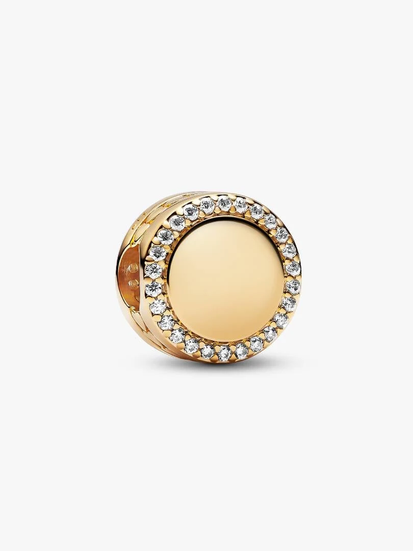 Charm circulaire plaqué or avec halo de zircons, vue de trois quarts sur fond blanc.