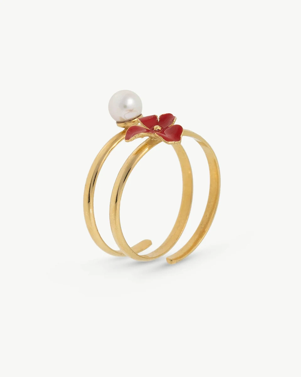 Anillo de banda abierta con flor roja esmaltada y perla blanca, vista frontal en ángulo sobre fondo blanco.