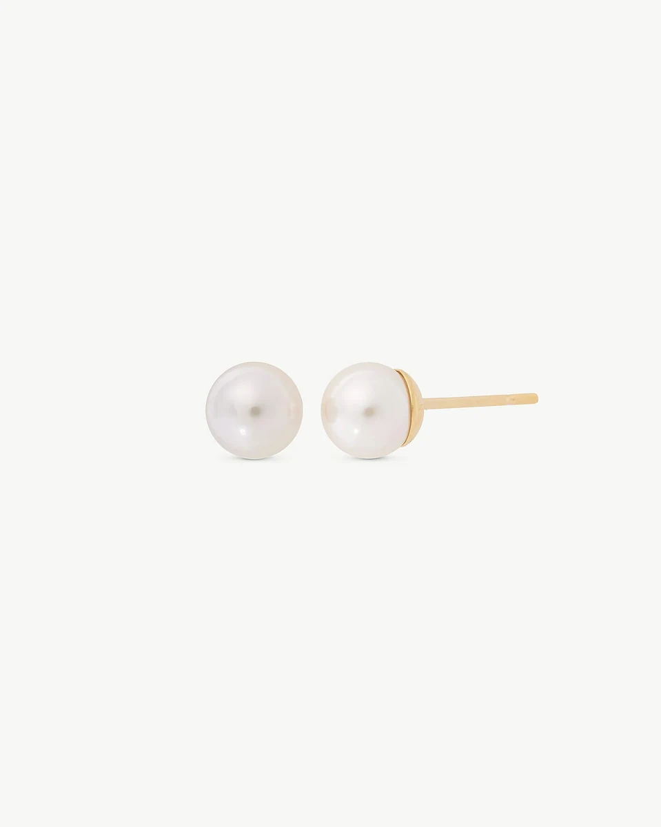 Side view of pearl stud earrings on a white background, showing the gold post.