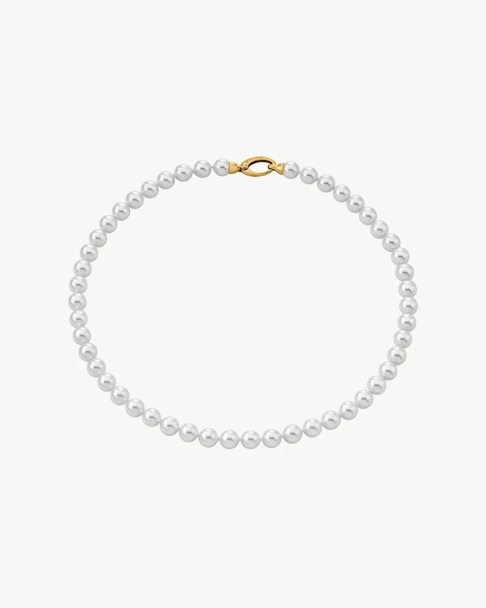Collier de perles disposé en cercle sur fond blanc, vue de face avec fermoir doré visible.