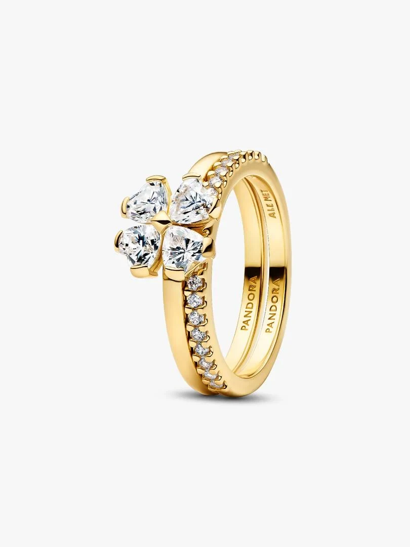 Vista en ángulo de dos anillos entrelazados con circonitas, fondo blanco neutro.