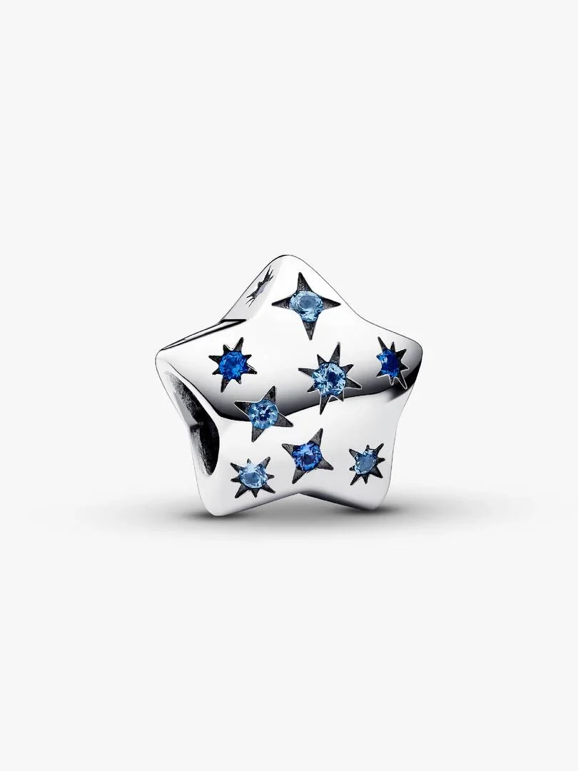 Charm étoile en argent avec cristaux bleus, vue de face inclinée sur fond blanc.