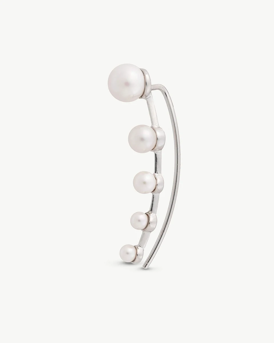 Silver crawler earring with five white pearls, side view on a white background.