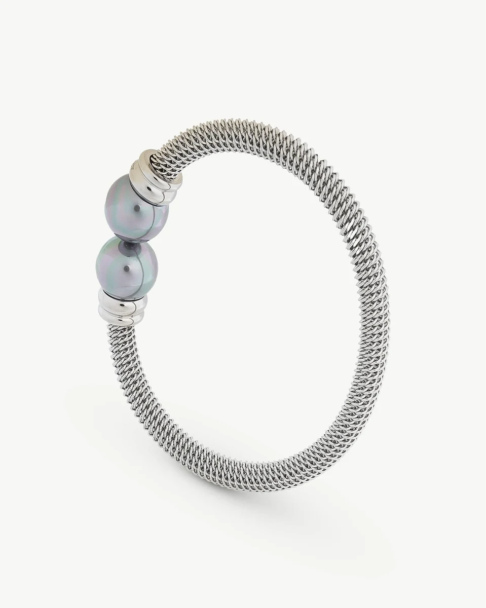 Bracelet jonc vu de profil sur fond blanc, mettant en valeur les deux perles grises centrales.